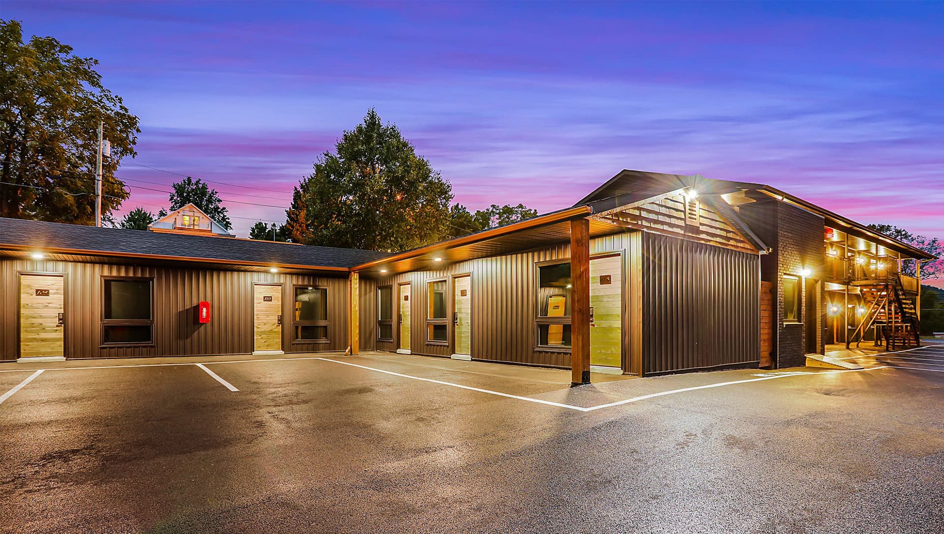 Modern building with wooden accents, brightly lit at dusk.