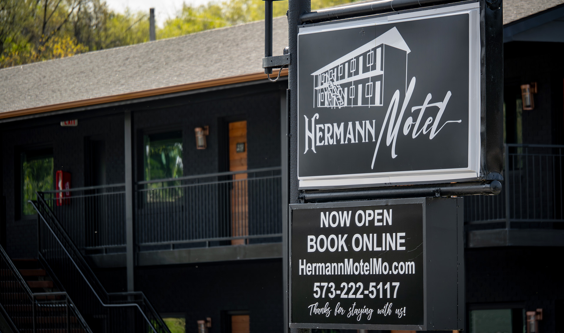 Sign for Hermann Motel with information on online booking.